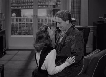 Movie still from “Woman of the Year” (1942), directed by George Stevens – A man and a woman sitting on a bench; Medium shot, High angle