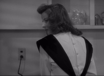 Movie still from “Woman of the Year” (1942), directed by George Stevens – A black and white photo of a woman in a dress; Medium shot, Over the shoulder angle