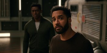 Movie still from “Another Life” (2019), created by Aaron Martin – Two men standing next to each other in front of a van; Medium shot, Over the shoulder angle