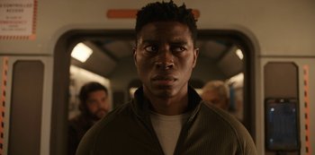 Movie still from “Another Life” (2019), created by Aaron Martin – A person in a subway car; Close Up shot, Over the shoulder angle