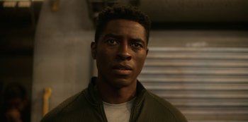 Movie still from “Another Life” (2019), created by Aaron Martin – A person wearing a jacket; Close Up shot, Low angle