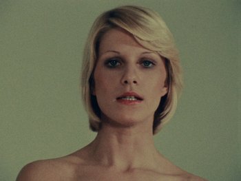 Movie still from “Women Reply” (1975), directed by Agnès Varda – A beautiful woman with blonde hair and a bare chest; Close Up shot, Low angle