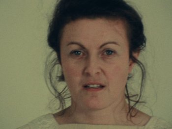 Movie still from “Women Reply” (1975), directed by Agnès Varda – A person wearing a white shirt; Close Up shot, Low angle