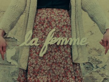 Movie still from “Women Reply” (1975), directed by Agnès Varda – A woman in a floral skirt and a sweater; Medium shot, Low angle