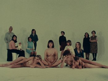 Movie still from “Women Reply” (1975), directed by Agnès Varda – A group of women sitting and standing around naked; Wide shot, High angle