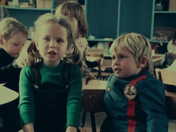 Movie still from “Women Reply” (1975), directed by Agnès Varda – Two young children are sitting in a classroom; Medium shot, High angle
