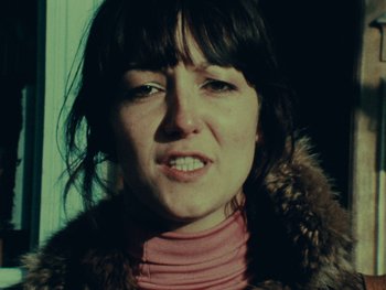 Movie still from “Women Reply” (1975), directed by Agnès Varda – A person wearing a jacket; Close Up shot, Low angle