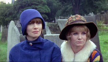 Movie still from “Women in Love” (1969), directed by Ken Russell – Two women wearing hats are standing next to each other; Close Up shot, Low angle