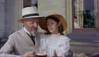 Movie still from “Women in Love” (1969), directed by Ken Russell – An older man and a young girl holding a glass of beer; Medium shot, Over the shoulder angle