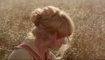 Movie still from “Women in Love” (1969), directed by Ken Russell – A woman with blonde hair is in a grassy field; Close Up shot, High angle