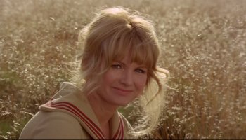 Movie still from “Women in Love” (1969), directed by Ken Russell – A woman with blonde hair is smiling for the camera; Close Up shot, Low angle