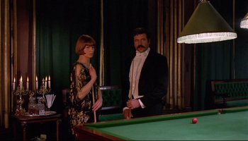 Movie still from “Women in Love” (1969), directed by Ken Russell – A man and a woman standing in front of a pool table; Medium shot, Over the shoulder angle