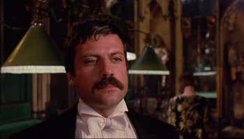 Movie still from “Women in Love” (1969), directed by Ken Russell – A person wearing a suit and a bow tie; Close Up shot, Low angle