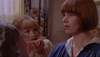 Movie still from “Women in Love” (1969), directed by Ken Russell – Two women eating a piece of food in a room; Close Up shot, Over the shoulder angle