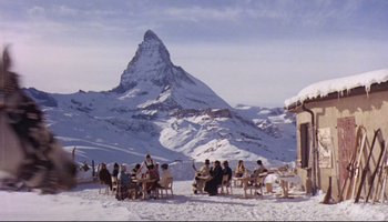 Movie still from “Women in Love” (1969), directed by Ken Russell – A group of people sitting at a table in the snow; Extreme Wide shot, High angle