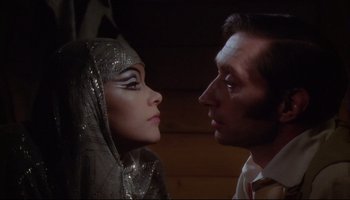 Movie still from “Women in Love” (1969), directed by Ken Russell – A man and a woman face to face in front of each other; Close Up shot, Low angle