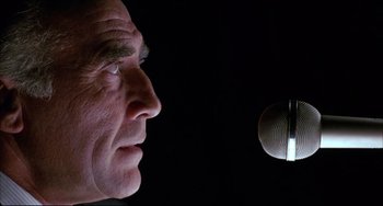 Movie still from “Women on the Verge of a Nervous Breakdown” (1988), directed by Pedro Almodóvar – A person's face with a microphone in the background; Close Up shot, Low angle