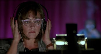 Movie still from “Women on the Verge of a Nervous Breakdown” (1988), directed by Pedro Almodóvar – A woman wearing glasses and headphones listening to music; Close Up shot, Low angle