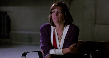 Movie still from “Women on the Verge of a Nervous Breakdown” (1988), directed by Pedro Almodóvar – A woman sitting in a chair with her arms crossed; Medium shot, Over the shoulder angle