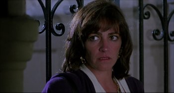 Movie still from “Women on the Verge of a Nervous Breakdown” (1988), directed by Pedro Almodóvar – A person wearing a purple jacket; Close Up shot, Low angle