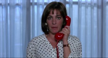 Movie still from “Women on the Verge of a Nervous Breakdown” (1988), directed by Pedro Almodóvar – A woman holding a red phone up to her ear; Close Up shot, High angle