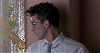 Movie still from “Women on the Verge of a Nervous Breakdown” (1988), directed by Pedro Almodóvar – A man wearing glasses and a white dress shirt and a tie; Close Up shot, Low angle
