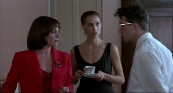 Movie still from “Women on the Verge of a Nervous Breakdown” (1988), directed by Pedro Almodóvar – A group of people standing next to each other holding a cup; Medium shot, Over the shoulder angle
