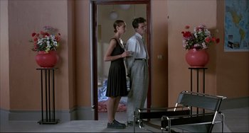 Movie still from “Women on the Verge of a Nervous Breakdown” (1988), directed by Pedro Almodóvar – A man and a woman standing next to each other in a room; Wide shot, Low angle