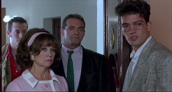 Movie still from “Women on the Verge of a Nervous Breakdown” (1988), directed by Pedro Almodóvar – A group of people standing next to each other in a room; Medium shot, Over the shoulder angle