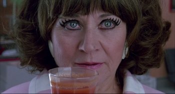 Movie still from “Women on the Verge of a Nervous Breakdown” (1988), directed by Pedro Almodóvar – A person holding a glass of orange juice; Extreme Close Up shot, Low angle