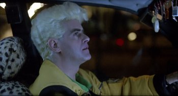 Movie still from “Women on the Verge of a Nervous Breakdown” (1988), directed by Pedro Almodóvar – A man with blonde hair sitting in the back of a car; Close Up shot, Low angle