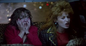 Movie still from “Women on the Verge of a Nervous Breakdown” (1988), directed by Pedro Almodóvar – Two women sitting in the back seat of a car; Close Up shot, Low angle