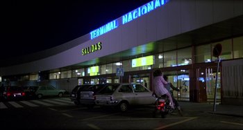 Movie still from “Women on the Verge of a Nervous Breakdown” (1988), directed by Pedro Almodóvar – A man on a motorcycle in front of a building; Extreme Wide shot, Low angle