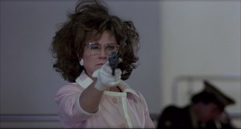 Movie still from “Women on the Verge of a Nervous Breakdown” (1988), directed by Pedro Almodóvar – A woman in glasses and a wig holding a gun; Medium shot, Low angle