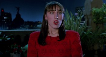 Movie still from “Women on the Verge of a Nervous Breakdown” (1988), directed by Pedro Almodóvar – A woman in a red dress is making a funny face; Close Up shot, Over the shoulder angle