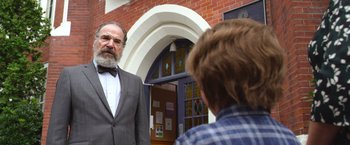 Movie still from “Wonder” (2017), directed by Stephen Chbosky – An older man wearing a suit and bow tie; Close Up shot, Over the shoulder angle
