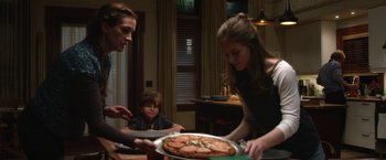 Movie still from “Wonder” (2017), directed by Stephen Chbosky – A woman and a boy are sitting at a table with a plate of pizza; Medium shot, Over the shoulder angle
