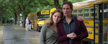 Movie still from “Wonder” (2017), directed by Stephen Chbosky – Two women standing next to each other in front of a school bus; Medium shot, Over the shoulder angle