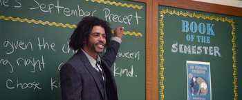 Movie still from “Wonder” (2017), directed by Stephen Chbosky – A man in a suit and tie writing on a chalkboard; Medium shot, Over the shoulder angle