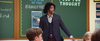 Movie still from “Wonder” (2017), directed by Stephen Chbosky – A man in a jacket and tie standing in front of a chalkboard; Medium shot, Over the shoulder angle