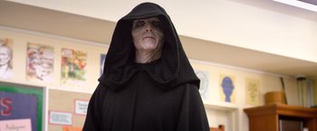 Movie still from “Wonder” (2017), directed by Stephen Chbosky – An old man dressed in a black robe and a black hood; Close Up shot, Over the shoulder angle