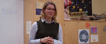 Movie still from “Wonder” (2017), directed by Stephen Chbosky – A woman wearing glasses standing in front of a wall; Medium shot, Over the shoulder angle