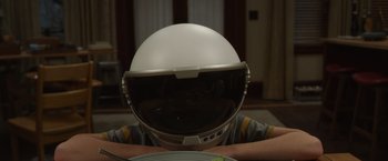Movie still from “Wonder” (2017), directed by Stephen Chbosky – A person wearing a helmet sitting in front of a plate; Close Up shot, Over the shoulder angle