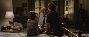 Movie still from “Wonder” (2017), directed by Stephen Chbosky – Two men and a boy sitting on a bed talking to each other; Medium shot, Over the shoulder angle