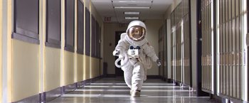 Movie still from “Wonder” (2017), directed by Stephen Chbosky – A person in a spacesuit walking down a hall way; Wide shot, Low angle