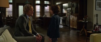 Movie still from “Wonder” (2017), directed by Stephen Chbosky – Two young men in suits are talking in a kitchen; Medium shot, Over the shoulder angle
