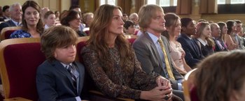 Movie still from “Wonder” (2017), directed by Stephen Chbosky – A group of people sitting in a row of seats; Medium shot, Over the shoulder angle