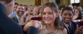 Movie still from “Wonder” (2017), directed by Stephen Chbosky – A girl is sitting in front of a group of people; Close Up shot, Over the shoulder angle