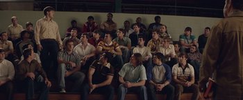 Movie still from “Woodlawn” (2015), directed by Jon Erwin – A group of men sitting in a gym watching a basketball game; Wide shot, High angle