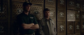 Movie still from “Woodlawn” (2015), directed by Jon Erwin – A couple of men standing next to each other in a room; Medium shot, Low angle